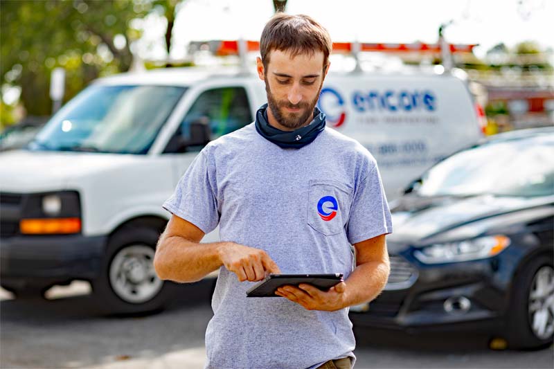 technician using tablet with Encore van in background