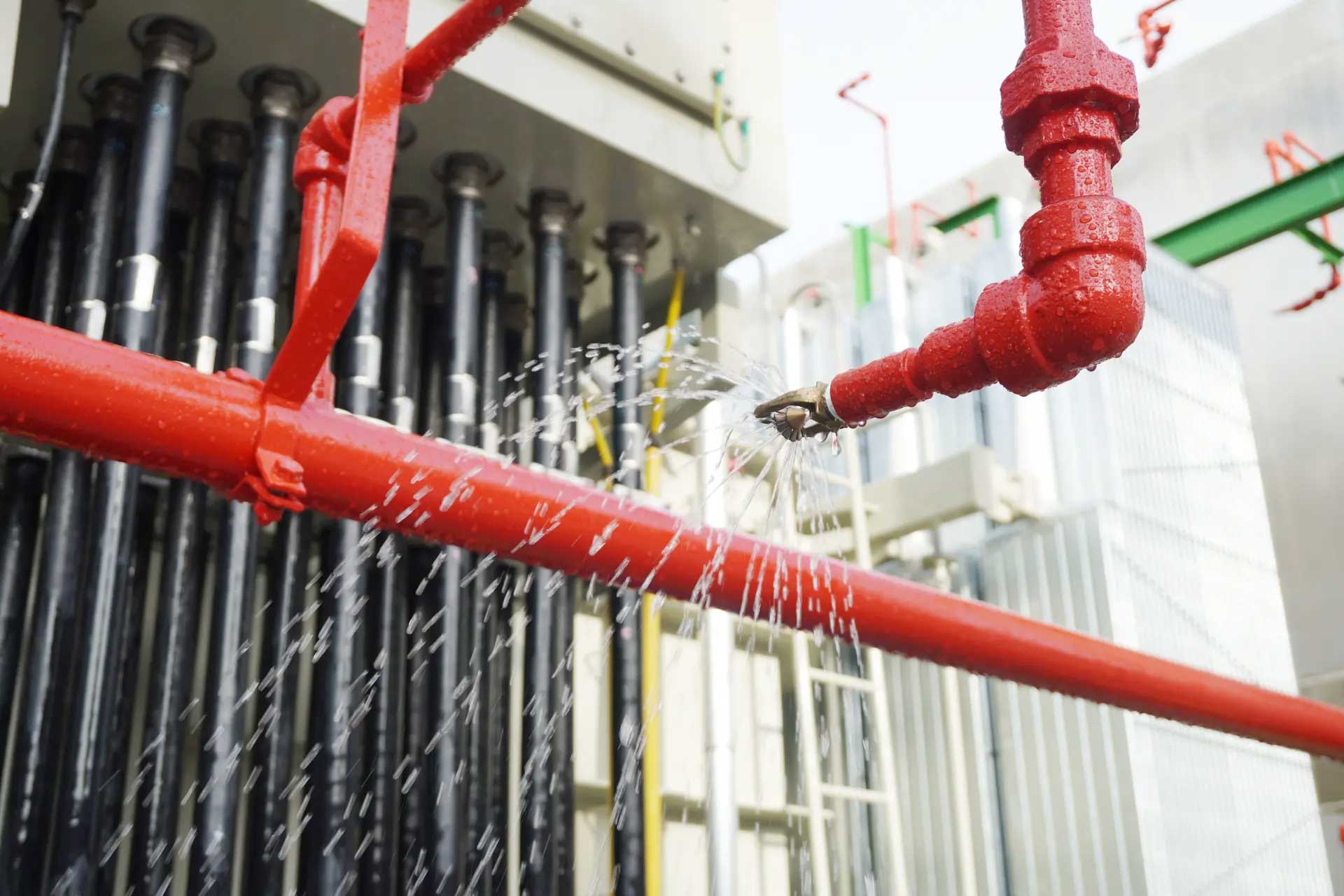 A fire sprinkler system releasing water during an activation test, ensuring fire suppression readiness in an industrial facility.